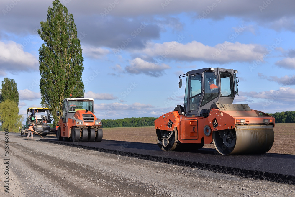 roller laying fresh asphalt . Road works with excavators. Construction of new roads on the highway in the field roller laying fresh asphalt . Road works with excavators. Construction of new roads on the highway in the field