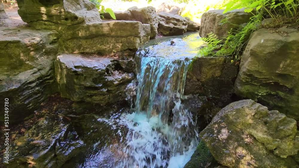 Video of a small waterfall, mossy rocks and flowing water stream. A ...