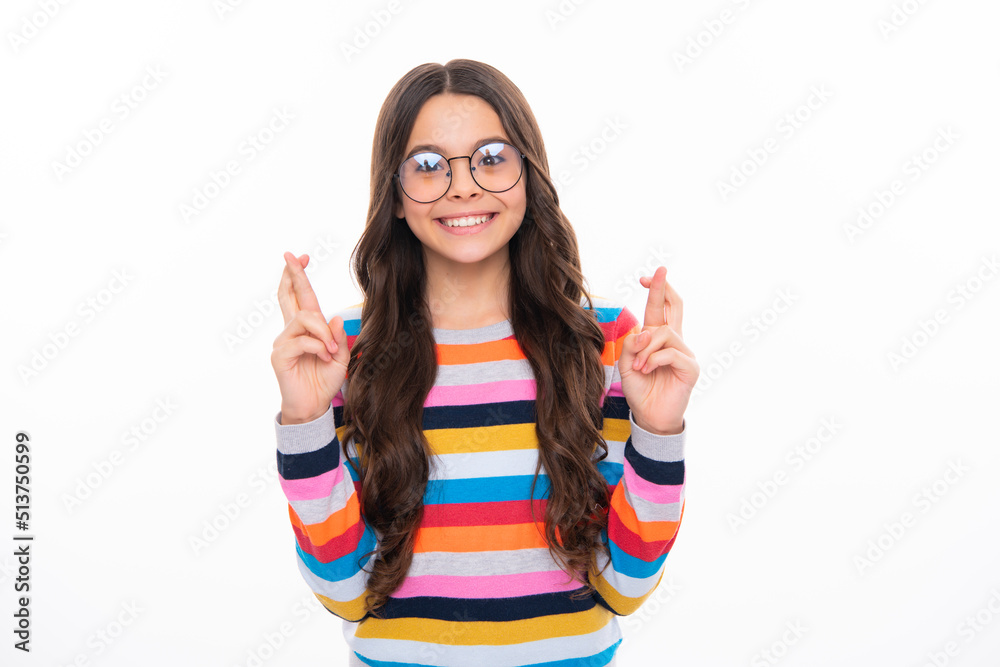 Happy girl face, positive and smiling emotions. Teenager child holding fingers crossed for good luck. Portrait of cheerful girl prays and hopes dreams come true isolated on white studio background. Happy girl face, positive and smiling emotions. Teenager child holding fingers crossed for good luck. Portrait of cheerful girl prays and hopes dreams come true isolated on white studio background.
