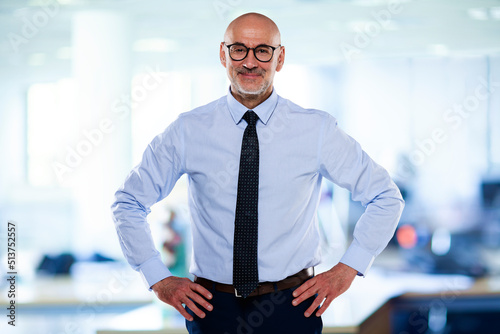 Photos Senior businessman wearing shirt and tie while standing at the office