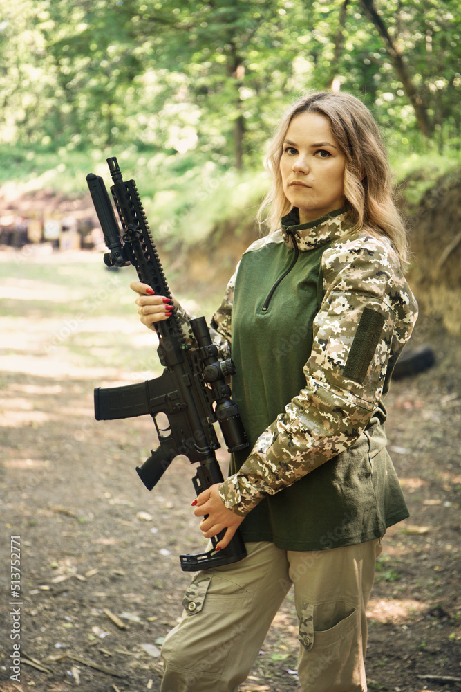 Fototapeta premium Portrait of a Ukrainian woman shooting from a machine gun Ar-15