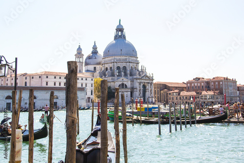 VENICE - AUGUST 27: A gondolier drives a gondola with tourists on board near Santa Maria Della Salute on August 27, 2018 in Venice, Italy