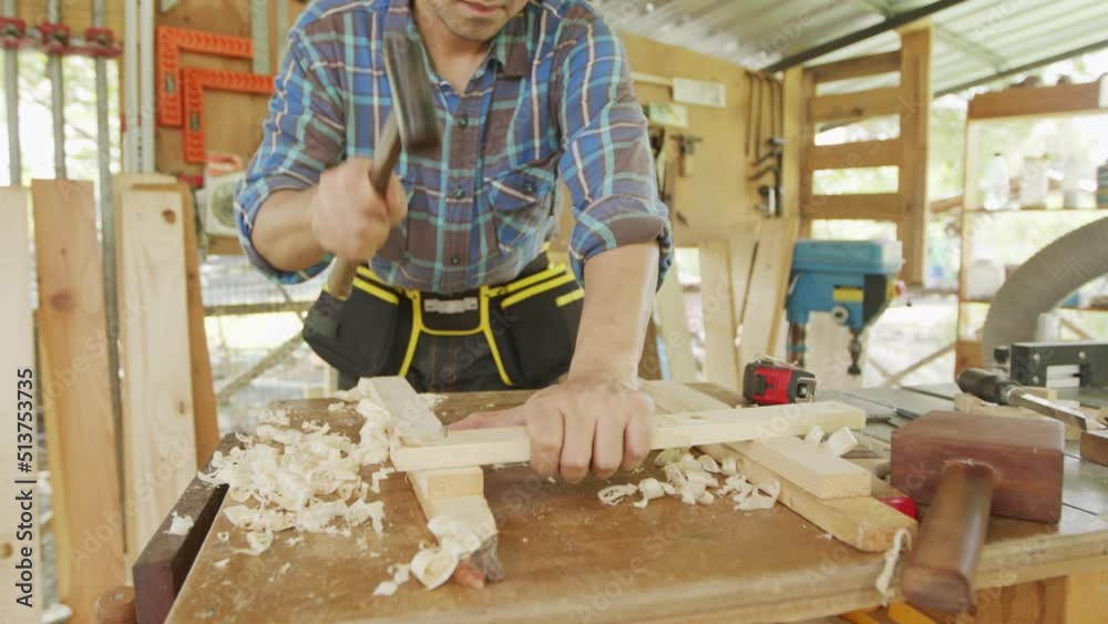 Close up carpenter hammering nails to process furniture Close up carpenter hammering nails to process furniture