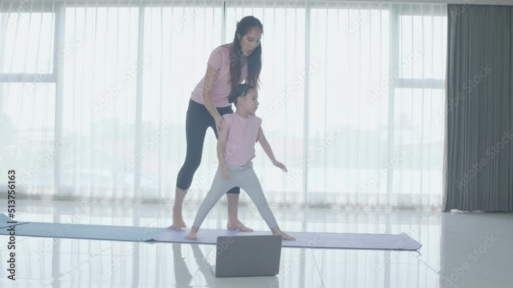 Happy Asian family exercise at home, mother fitness and doing yoga and exercise with cute funny daughter, fitness online in house, young girl workout with mom, good health