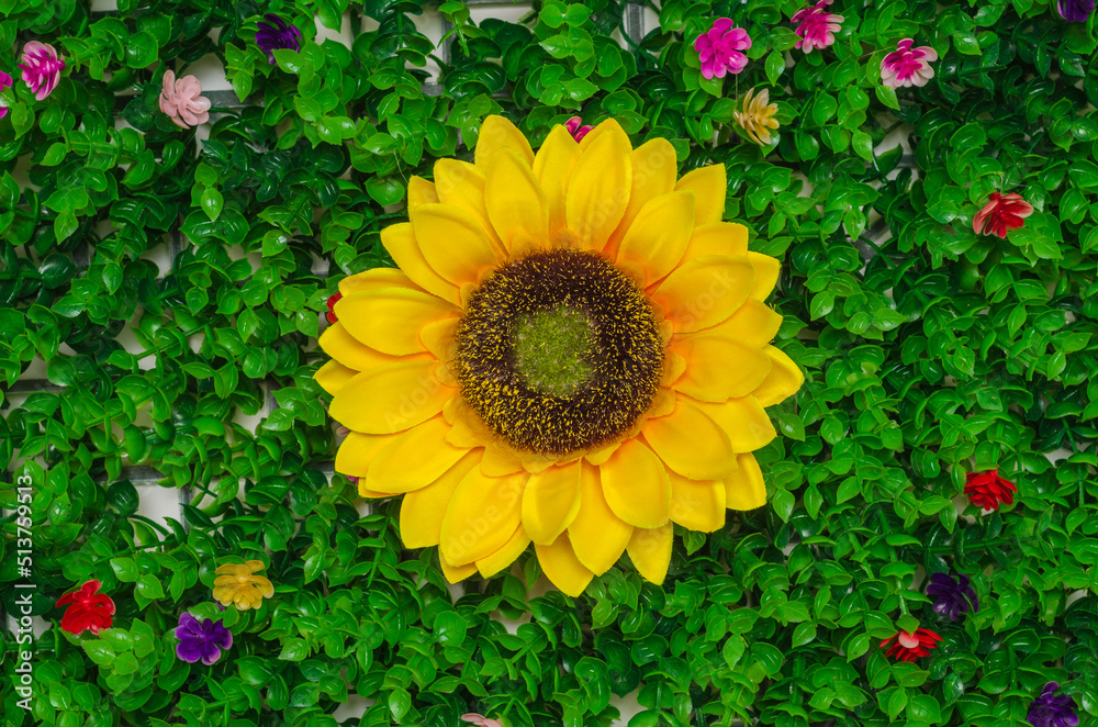 Obraz premium artificial sunflower on artificial green grass