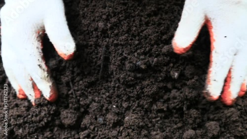 Farmer hand testing organic soil by pouring to below slow motion shot