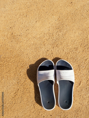 The sea on the beach, slippers, feet in sandals on the background of beach sand. travel holidays concept. High quality photo