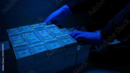 Thief Loads Bag With Money In Blue Security Light photo