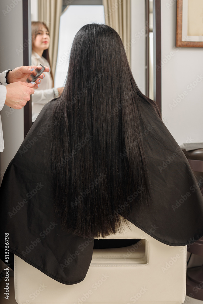 Fototapeta premium Beauty girl with long straight brunette hair having treatment in beauty salon