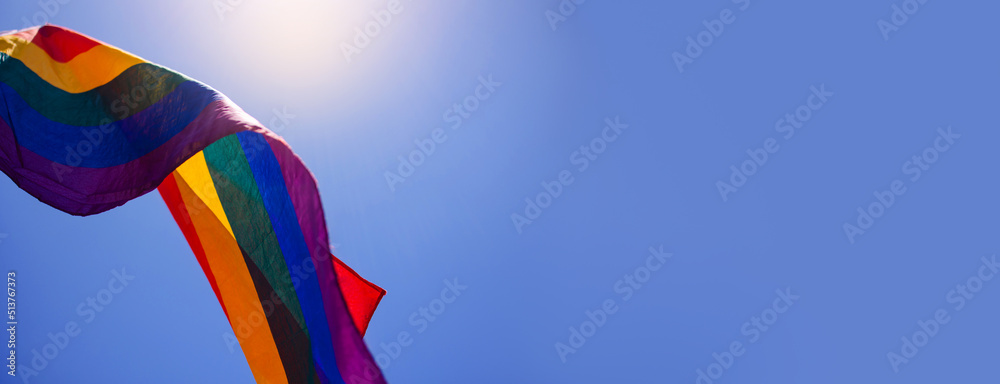 Banner with waving lgbt+ flag. Copy space for text. Summer holiday is the month of pride. Symbol of freedom of tolerance and equal rights of homosexuals. Six colors rainbow against the sky. June Banner with waving lgbt+ flag. Copy space for text. Summer holiday is the month of pride. Symbol of freedom of tolerance and equal rights of homosexuals. Six colors rainbow against the sky. June