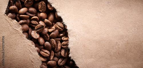 Roasted coffee beans decorated with kraft paper close-up creative background © amixstudio
