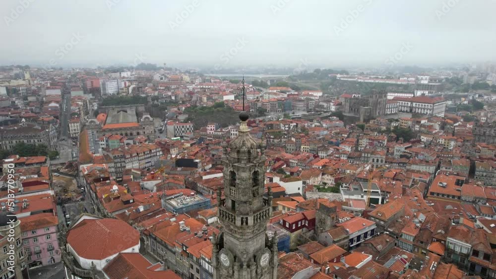 Cinematic foggy aerial view of Clerigos Church Baroque Bell Tower, a Famous City Landmark, in Porto, Portugal Cinematic foggy aerial view of Clerigos Church Baroque Bell Tower, a Famous City Landmark, in Porto, Portugal