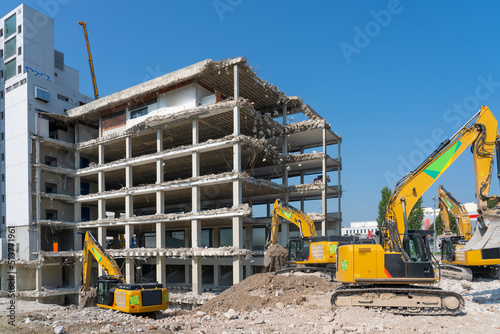 heavy duty Excavators demolishing an old commercial business house building