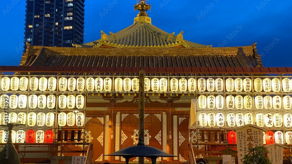Beautiful Japanese temple at night with paper lanterns lit brightening the blue vivid sky, “Bentendo” temple at Ueno park Shinobazu pond island, year 2022 June 25th