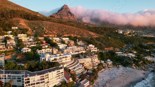 sunset of hotels at Clifton Beach with clouds rolling over lions head in Cape Town, aerial