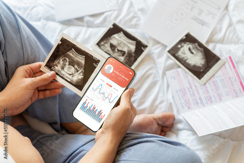 Pregnancy smartphone app. Pregnant woman holding smartphone. Mobile pregnancy online maternity application. Concept maternity, pregnancy, childbirth. photo