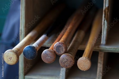 Photography Old wood baseball bats in a bat storage rack at a baseball park