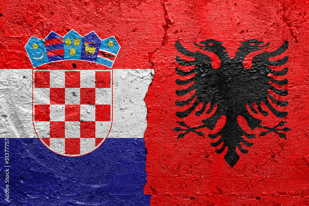 Croatia and Albania - Cracked concrete wall painted with a Croatian flag on the left and a Albanian flag on the right stock photo
