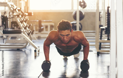 Muscular man doing push up in the gym. Athletic man doing exercise with push up. Man work out push up in the gym. Sport fitness and healthy lifestyle.