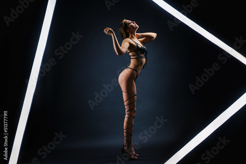 Fashion photo of beautiful lady with perfect body in photo studio strip light. photo