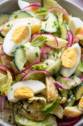Potato salad with eggs, cucumbers, cabbage and red pickled onions. Delicious healthy summer salad.