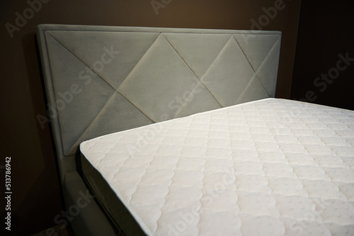 Comfortable modern stylish gray double beds with orthopedic hard mattresses  displayed for sale in the showroom of a furniture store. Partial view