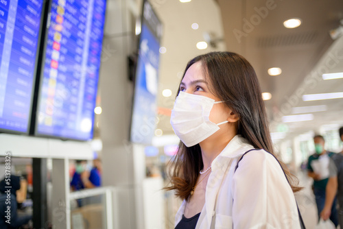 A traveller woman is wearing protective mask in International airport, travel under Covid-19 pandemic, safety travels, social distancing protocol, New normal travel concept ..