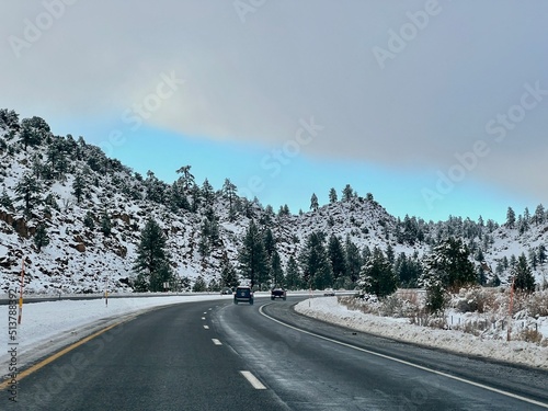 Cars driving south from Mammoth ski resort, on snowy, wet highway, US Route 395, Mammoth Lakes, California