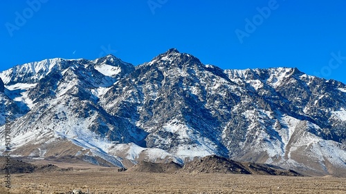 Snow-covered mountains and scrubland in foreground, near Fort Independence in Southern California
