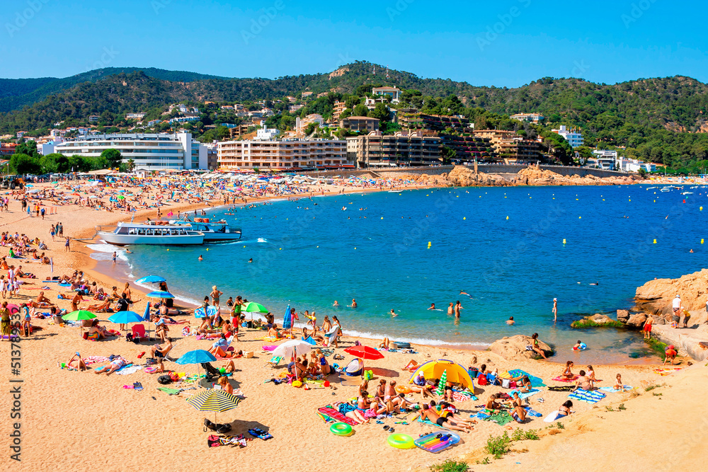  A crowd of vacationers enjoy the warm beaches of Costa Brava. Tossa de Mar, Spain.