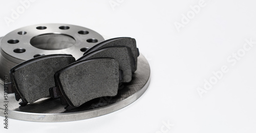 Brake disc and brake pads on a white background. Close-up, selective focus on the brake pads. copy space.
