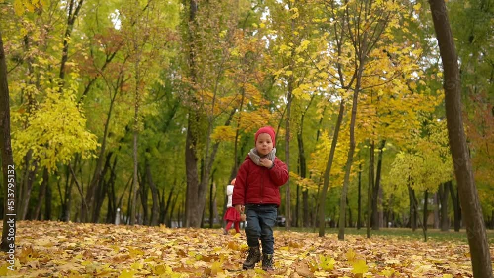 One sad upset tired child kid boy walking in park enjoying autumn fall nature weather. Kid Collect throw up falling leaves in baskets, playing hiding behind trees on forest landscape. Childhood One sad upset tired child kid boy walking in park enjoying autumn fall nature weather. Kid Collect throw up falling leaves in baskets, playing hiding behind trees on forest landscape. Childhood