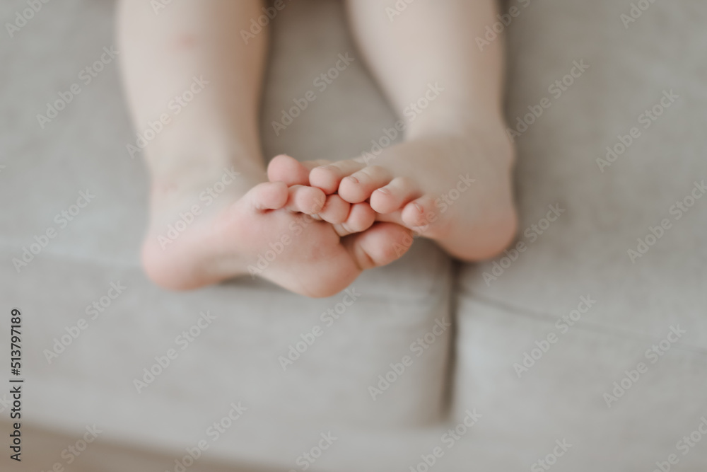 child bare little feet close-up indoors. child sitting barefoot child bare little feet close-up indoors. child sitting barefoot