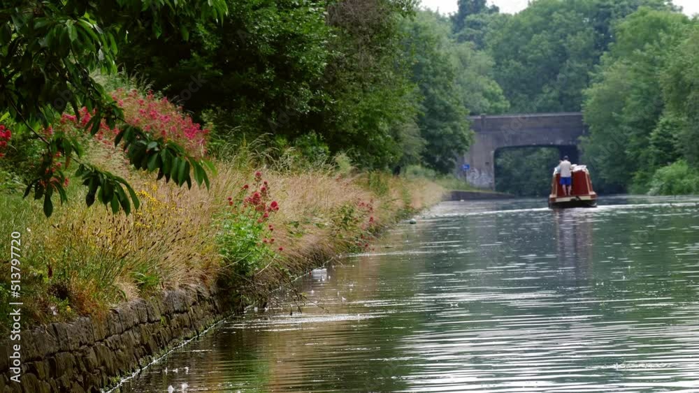 Barge on canal waterway in England on summer day wide establishing Barge on canal waterway in England on summer day wide establishing