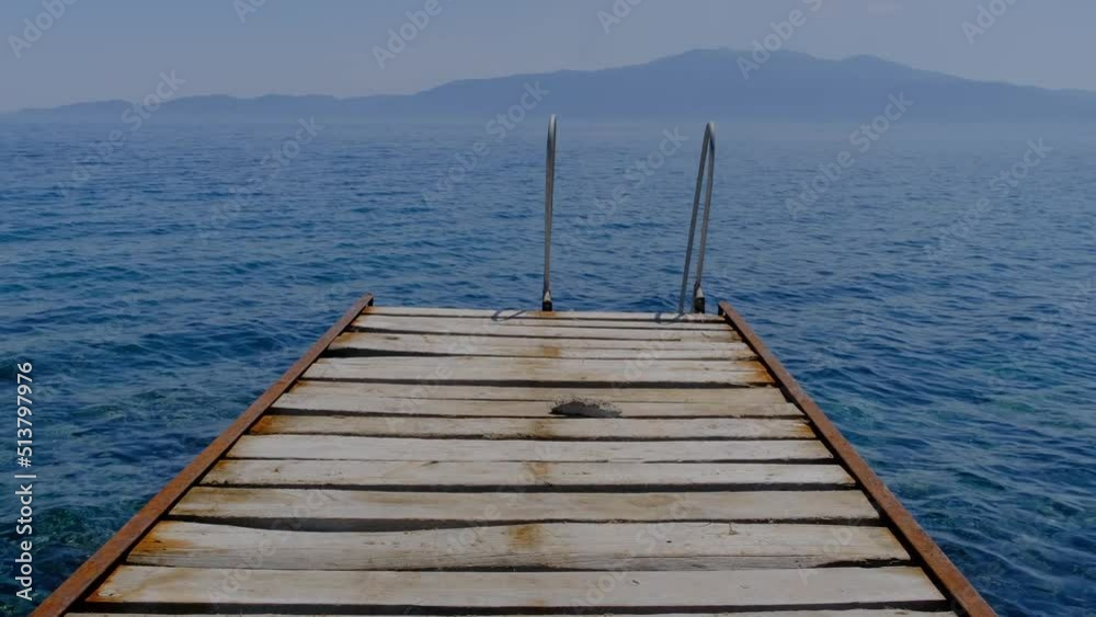 Old rusty pier swimming platform in Assos - Canakkale located at Aegean coasts of Turkey. Midilli - Lesbos Island in the background. Old rusty pier swimming platform in Assos - Canakkale located at Aegean coasts of Turkey. Midilli - Lesbos Island in the background.