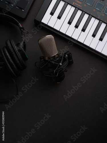 Microphone and media keyboard on a gray background. Professional equipment for the recording studio. Music, singing, television, radio, concerts, rehearsals.