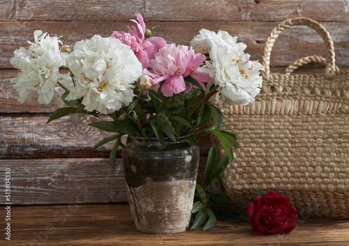 Obraz na płótnie Still life with white and pink peonies in a old ceramic vase on wooden background w salonie