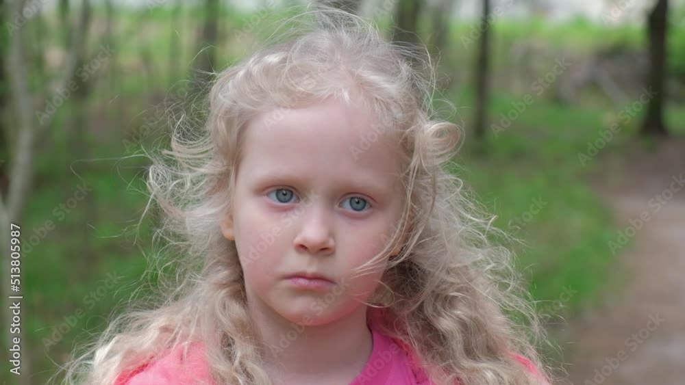 Happy blond girl iwith curly hair n rays of the sun. Girl in park or forest close-up. Happy blond girl iwith curly hair n rays of the sun. Girl in park or forest close-up.