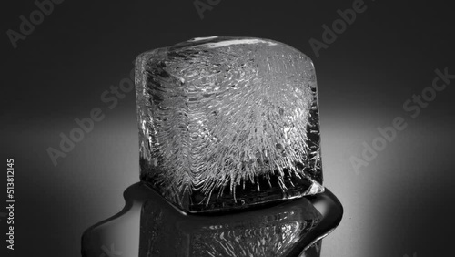 Melting ice cube, water flowing to foreground (viewer). Double speed version. 