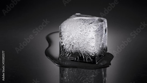 Melting ice cube, water flowing to background, later to foreground. 