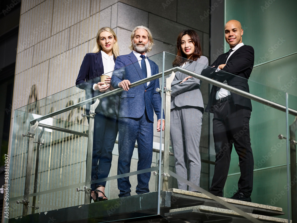 team of multiethnic business men and women standing inside a modern office building team of multiethnic business men and women standing inside a modern office building