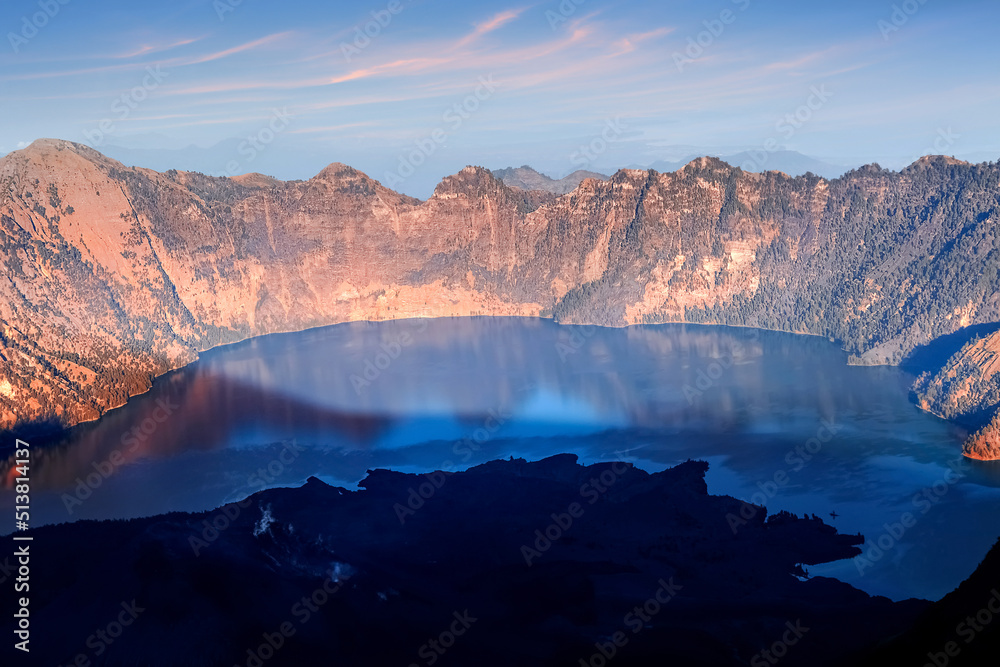 Lake in the crater of a volcano at sunset. Reflection of  water. Indonesia. Rinjani volcano.