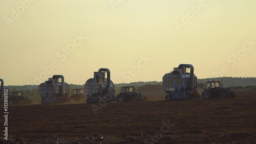 Peat harvester agricultural tractors on collecting extracting peat at sunset. Mining peatland.
