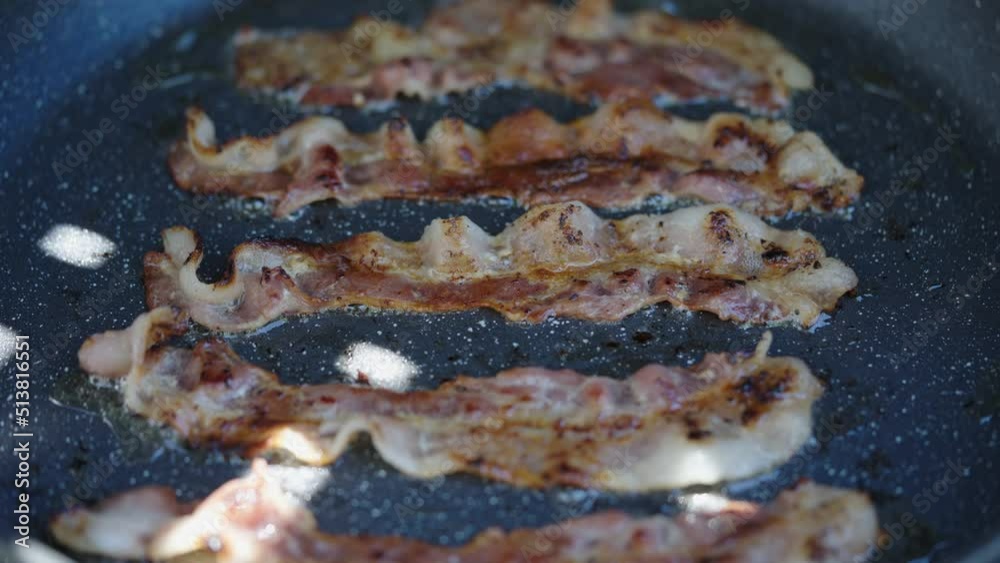 Crispy Bacon Slices are Fried in a Hot Pan for Breakfast, Close Up View. American Food Concept Crispy Bacon Slices are Fried in a Hot Pan for Breakfast, Close Up View. American Food Concept