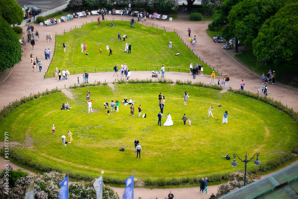 Square, round green field with walking people, wedding celebration Square, round green field with walking people, wedding celebration