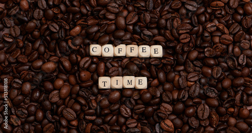 the words Coffee Time laid with wooden cubes on coffee beans in banner size