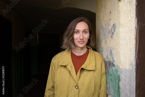 Fotografi young caucasian smiling woman with short hair standing alone at corridor