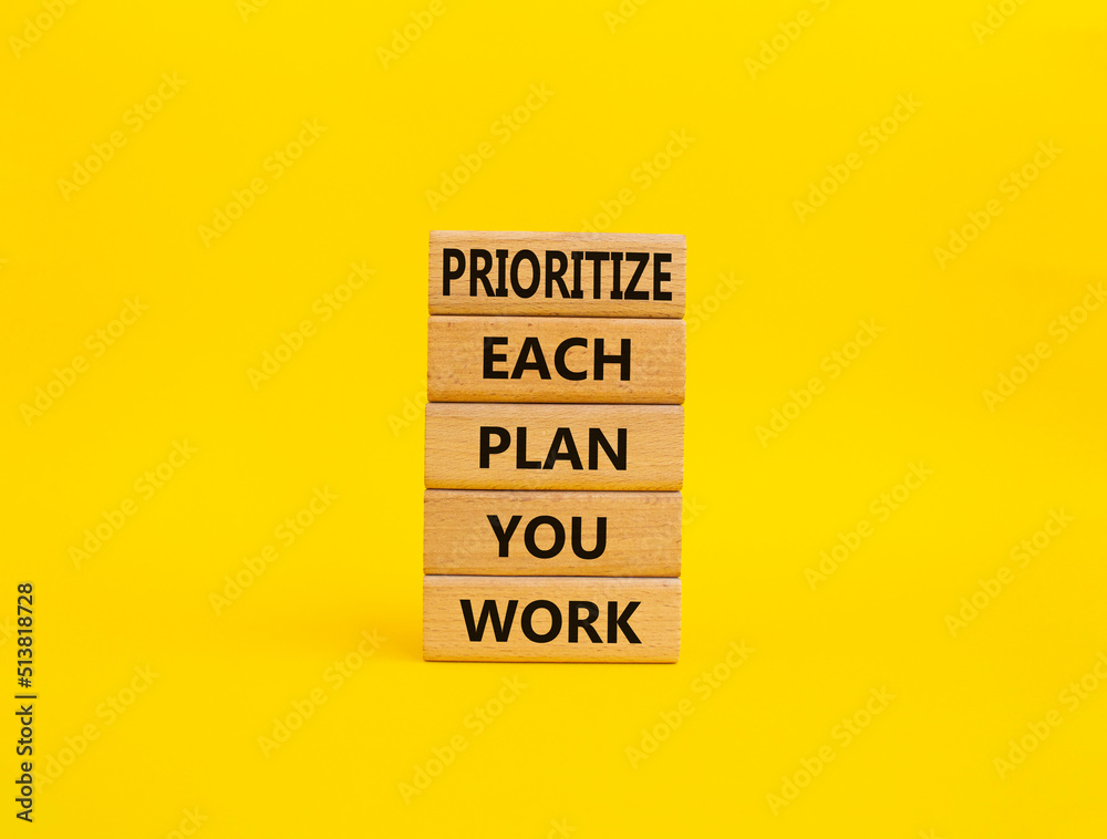Naklejka premium Priority, plan and work symbol. Wooden blocks with words Prioritize each plan you work. Beautiful yellow background. Business and Prioritize each plan you work concept. Copy space