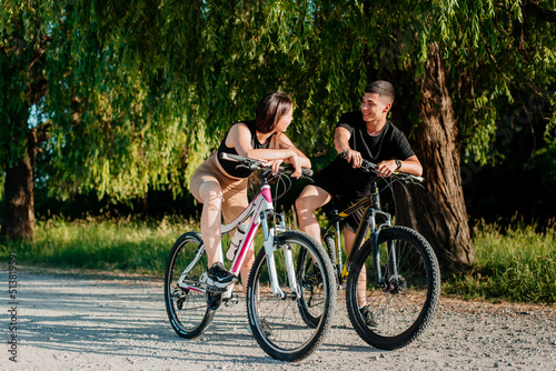 Young couple ride bicycles in the park.
