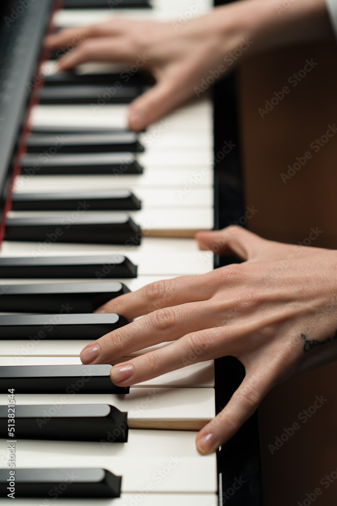 refined woman pianist plays the piano with thin fingers, sensually plays a musical instrument